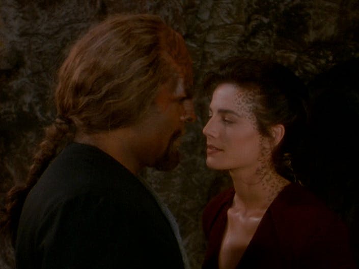 Following a bat'leth duel in the holosuite, Worf and Jadzia Dax stand closely face-to-face in an intimate moment in 'Sons of Mogh'