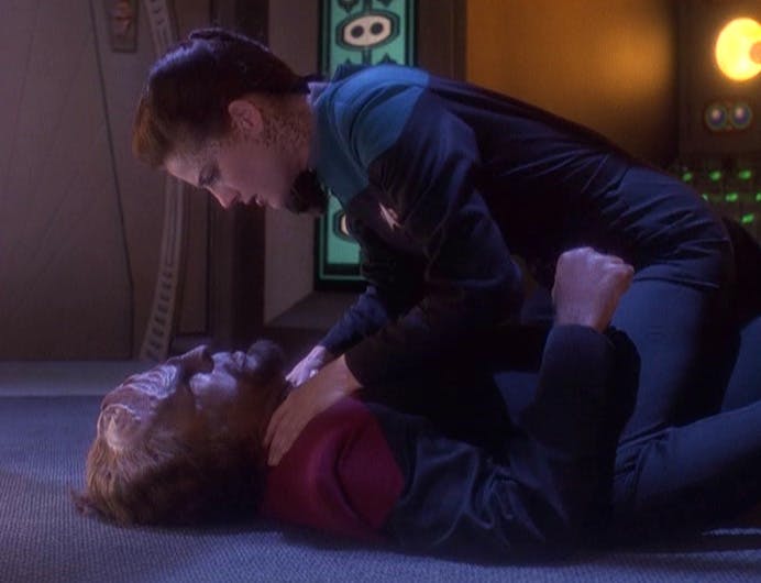 Jadzia Dax overtakes Worf and straddles his body on top of him with her hands wrapped around his neck gazing intensely at him in 'Looking for par'Mach in All the Wrong Places'