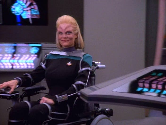 Melora grins while seated in her wheelchair in 'Melora'