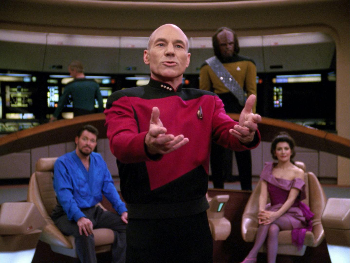 On the bridge of the Enterprise-D, in front of the seated Will Riker and Deanna Troi, and Worf, Jean-Luc Picard extends his arms outright to convince the Ferengis he needs his beloved Lwaxana Troi back in 'Ménage à Troi'