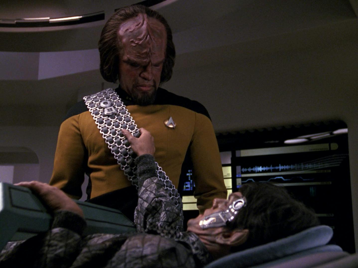 Worf lets a wounded Romulan die as he grips onto Worf's Klingon sash in 'The Enemy'