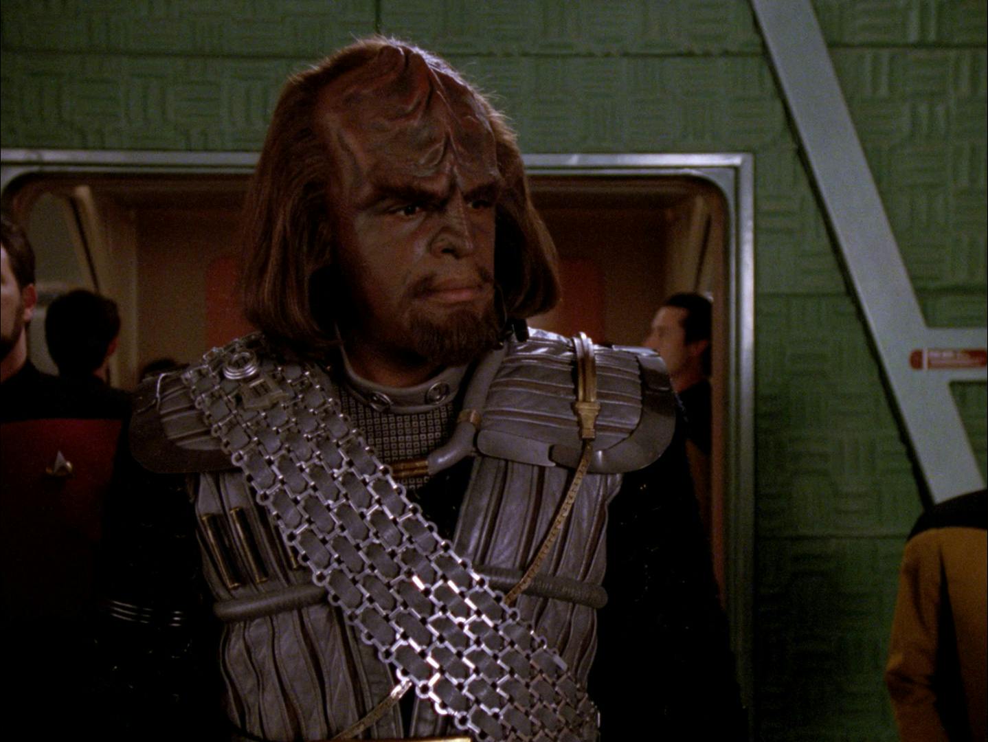 In the transporter room, Worf wears his full Klingon uniform in 'Redemption'