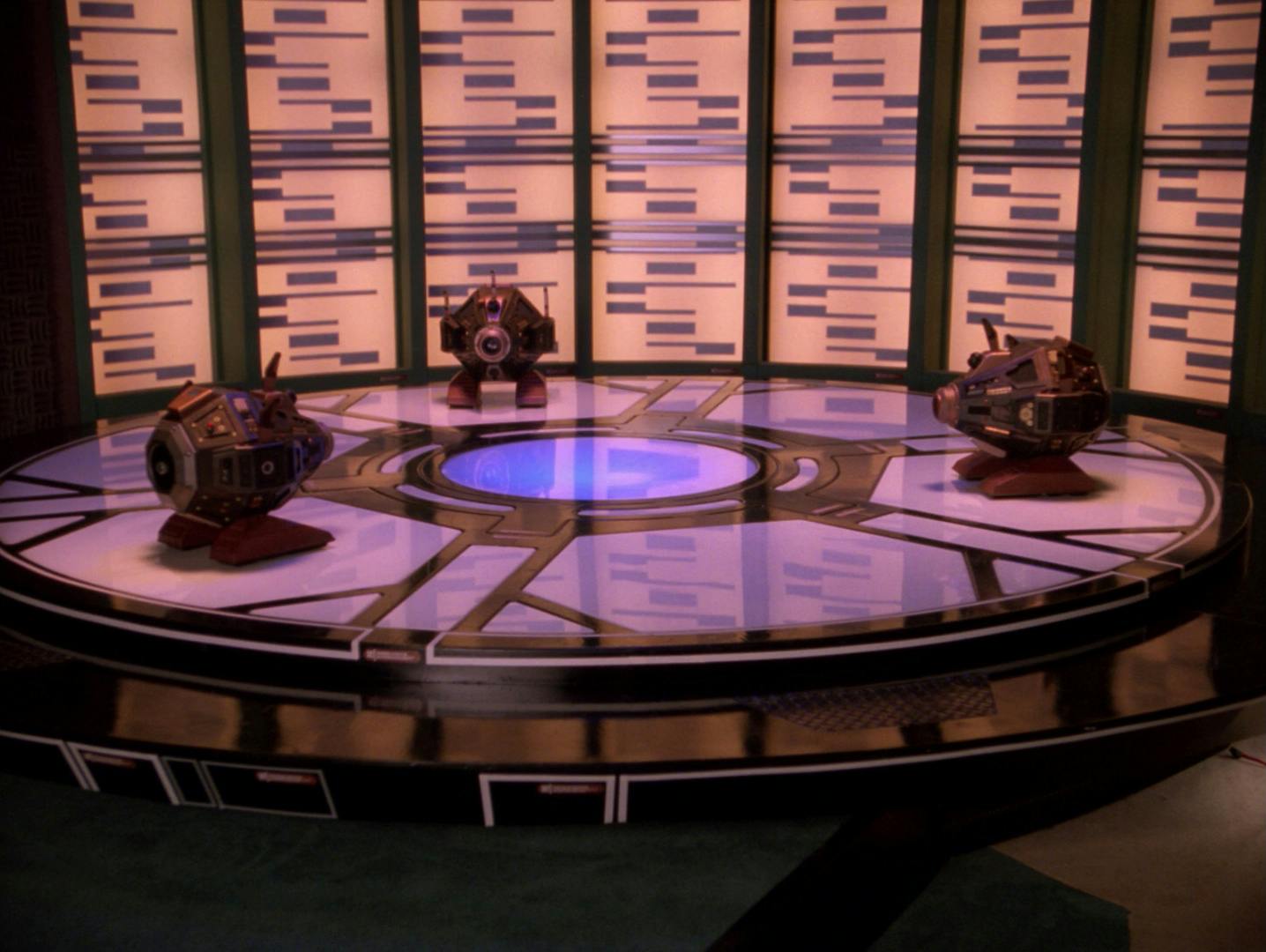 Three exocomps are on the Enterprise-D's transporter pad in 'The Quality of Life'