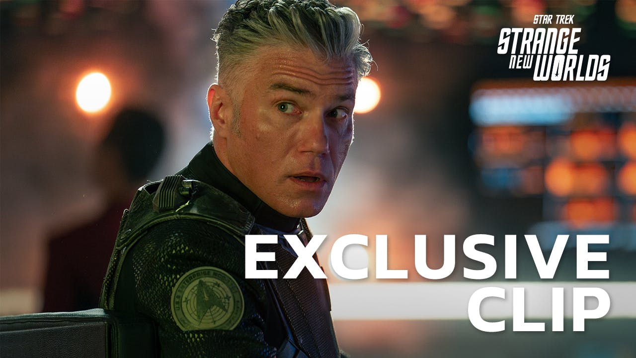 Episodic still of Captain Pike in combat uniform wearing a concerned expression as he looks over his shoulder with the Strange New Worlds logo and 'Exclusive Clip' text