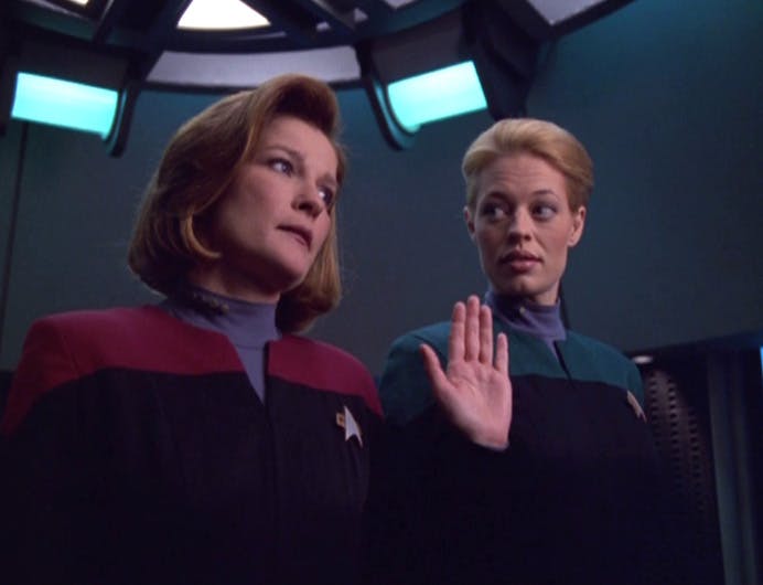 On the Voyager transporter pad, Janeway raises her hand as Seven of Nine goes undercover as a science officer in 'Relativity'