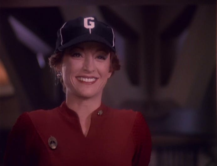 Kira Nerys wears a baseball cap in Sisko's officer after he throws it at her in 'Starship Down'