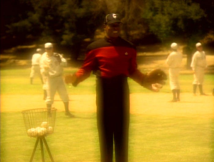 In a vision, Sisko is on the baseball field in his Starfleet uniform with a baseball hat and catcher's mitt in 'Emissary'