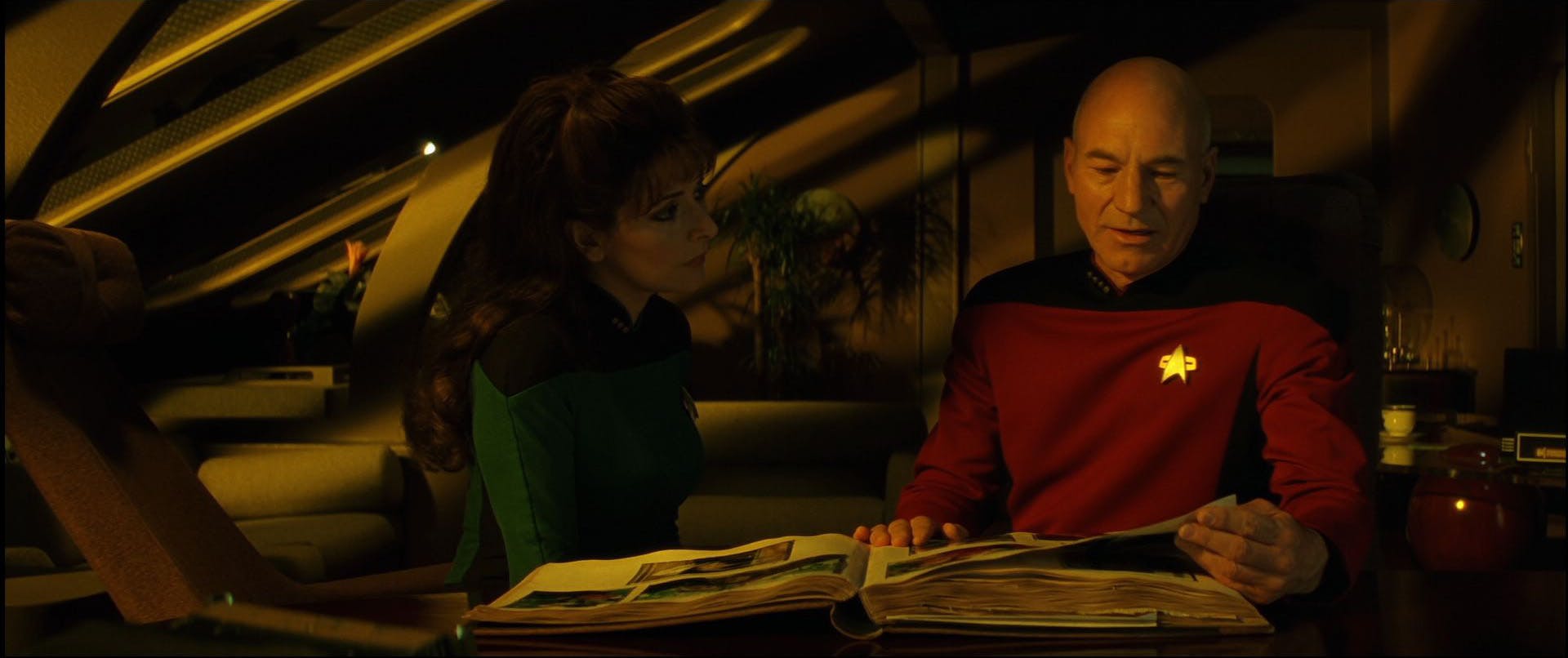 Jean-Luc Picard flips through a family photo album as Counselor Troi comes to sit beside him in 'Star Trek Generations'