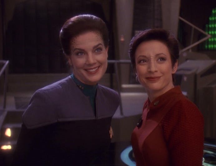 At their station, Jadzia Dax and Kira turn around and warmly grin in 'A Simple Investigation'