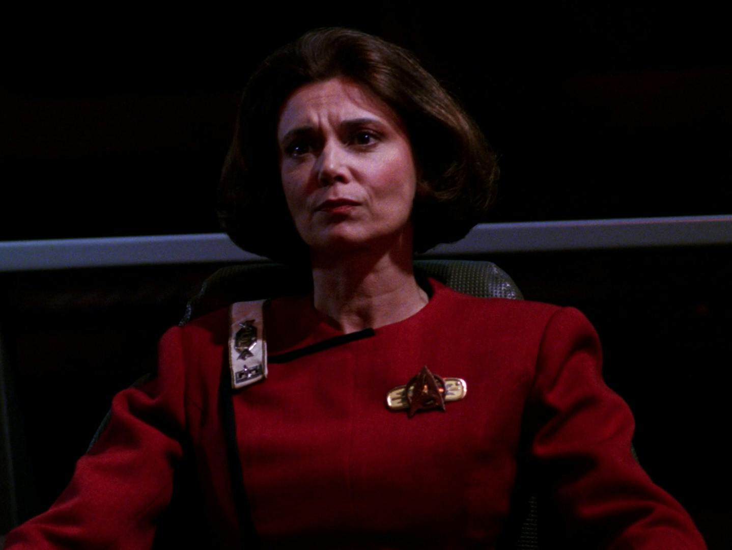 With a stern expression, Captain Rachel Garrett sits in the command seat aboard her ship the Enterprise-C in 'Yesterday's Enterprise'