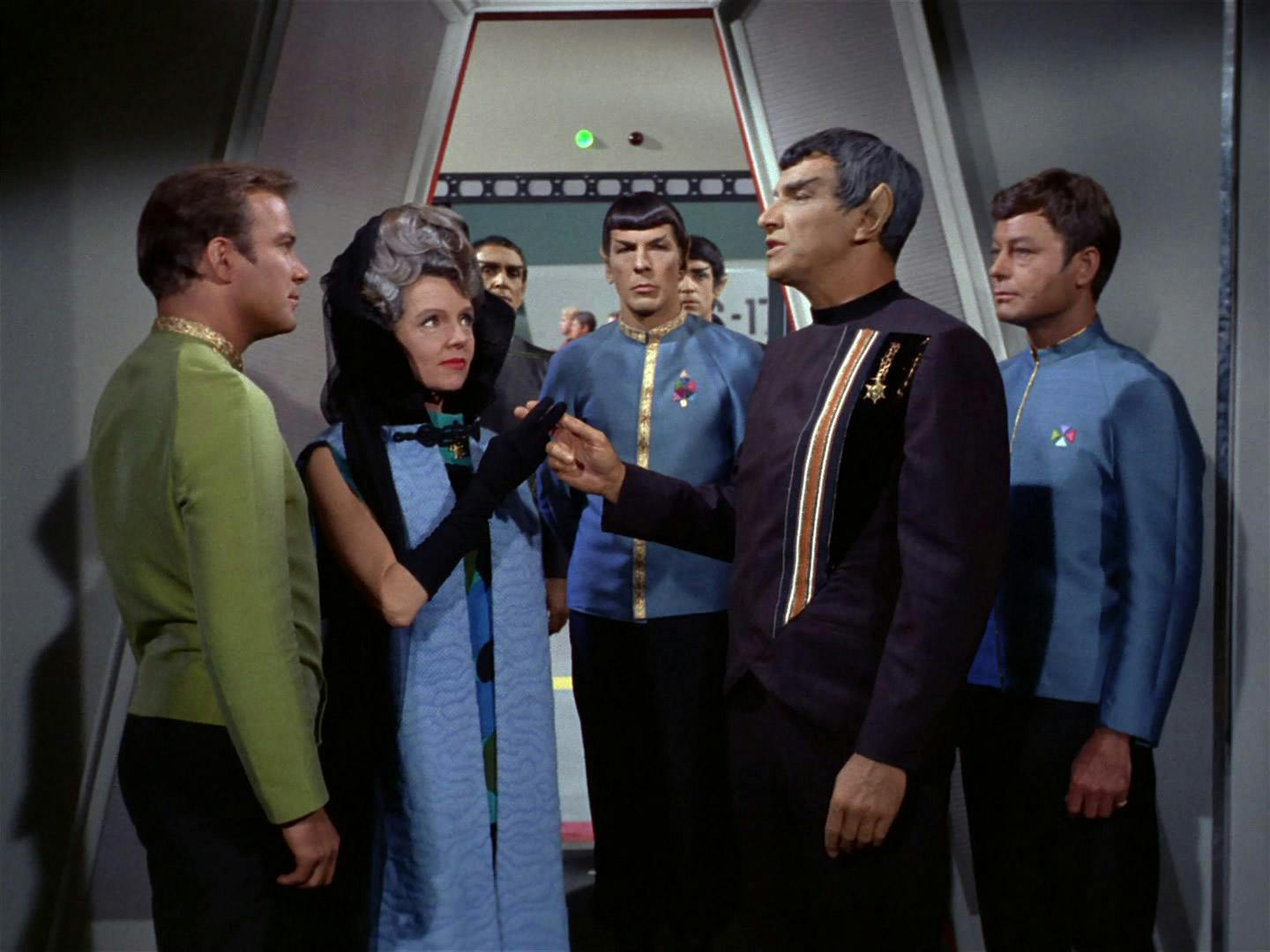 Hosting a conference aboard the Enterprise, Kirk greets the Vulcan ambassadors (and Spock's parents) Amanda Grayson and Sarek as Spock and McCoy stand by in 'Journey to Babel'