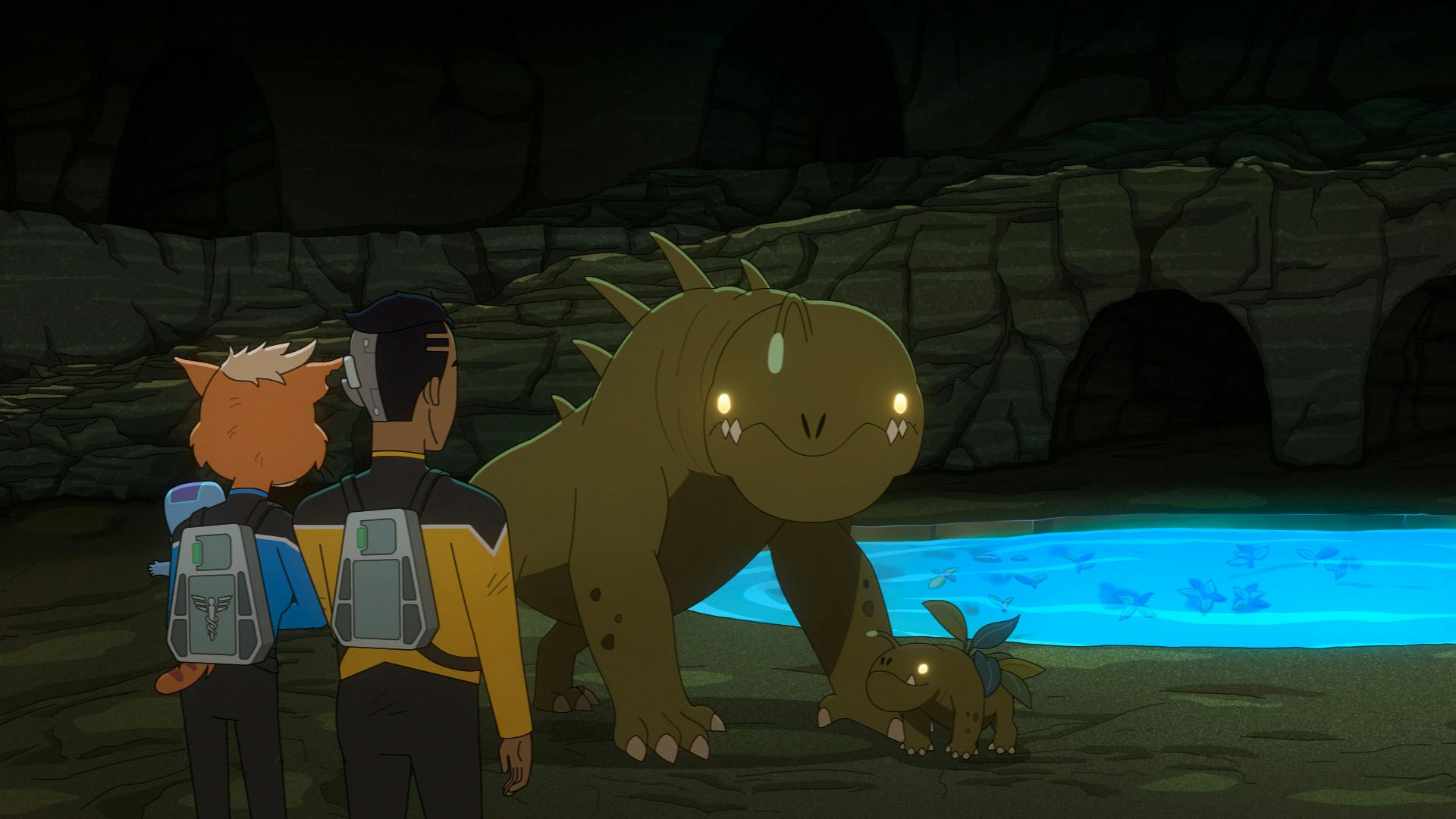 Dr. T'Ana and Rutherford while holding their baby look over at the mother Grafflax and her baby in front of a body of water in 'Caves'