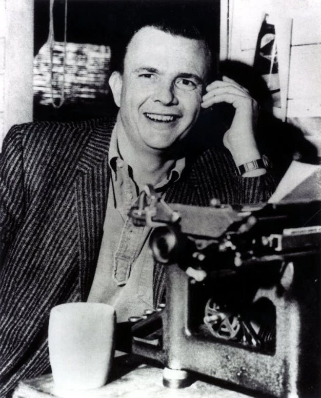 Portrait of a smiling Gene Coon with a phone held to his ear