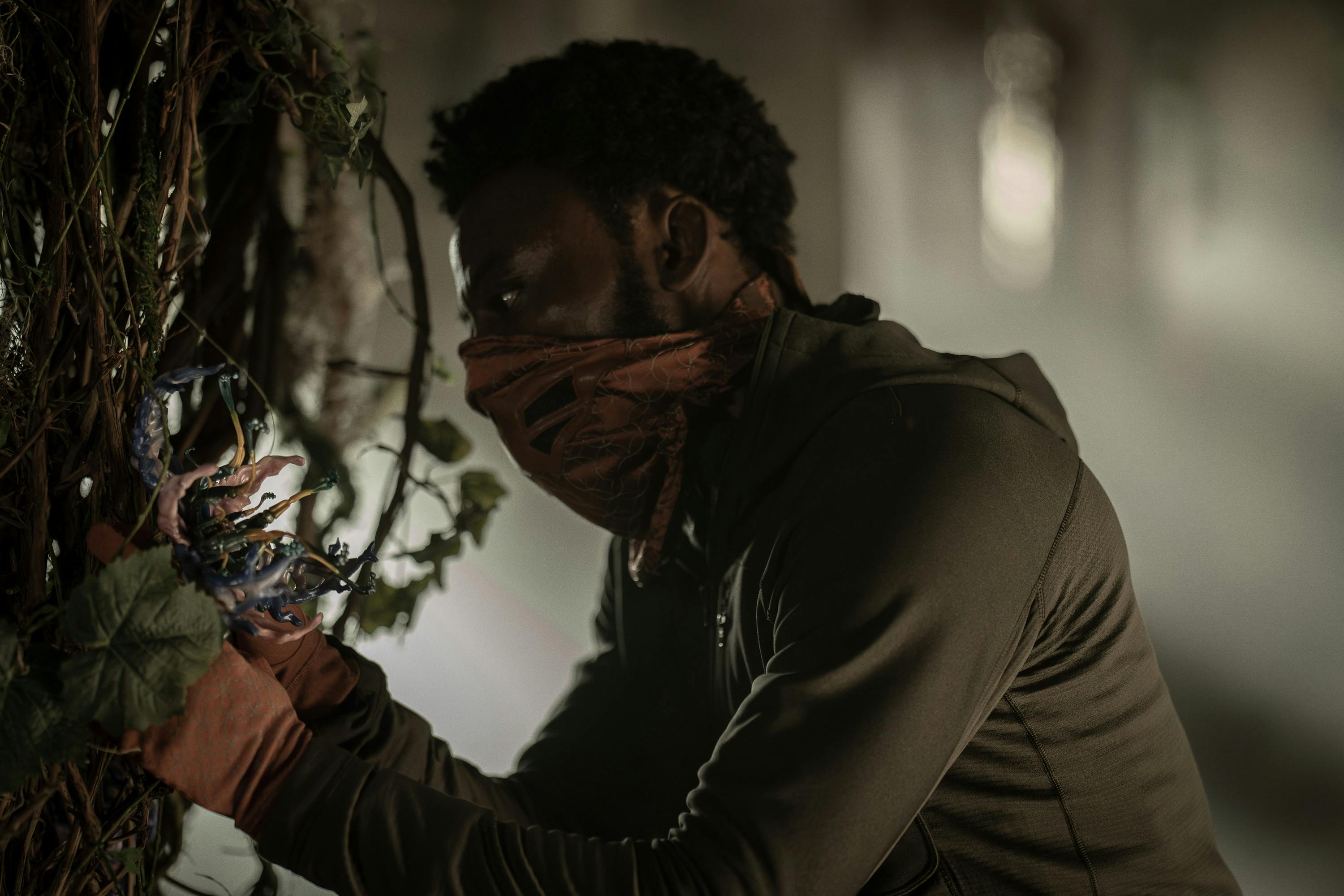M'Benga, masked and gloved, plucks a Chimera Blossom in a Klingon research facility in 'Shuttle to Kenfori'