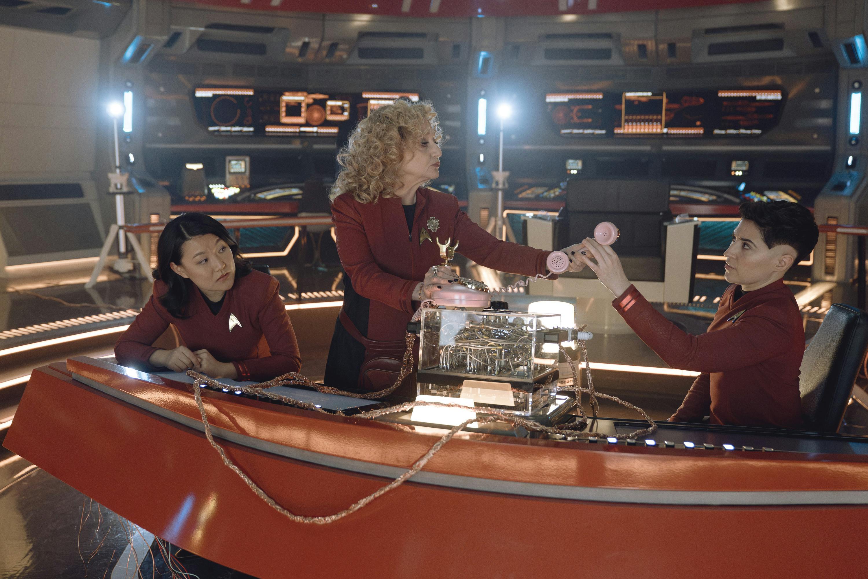 Pelia hands Ortegas a wired phone receiver on the Bridge in 'The Sehlat Who Ate Its Tail'