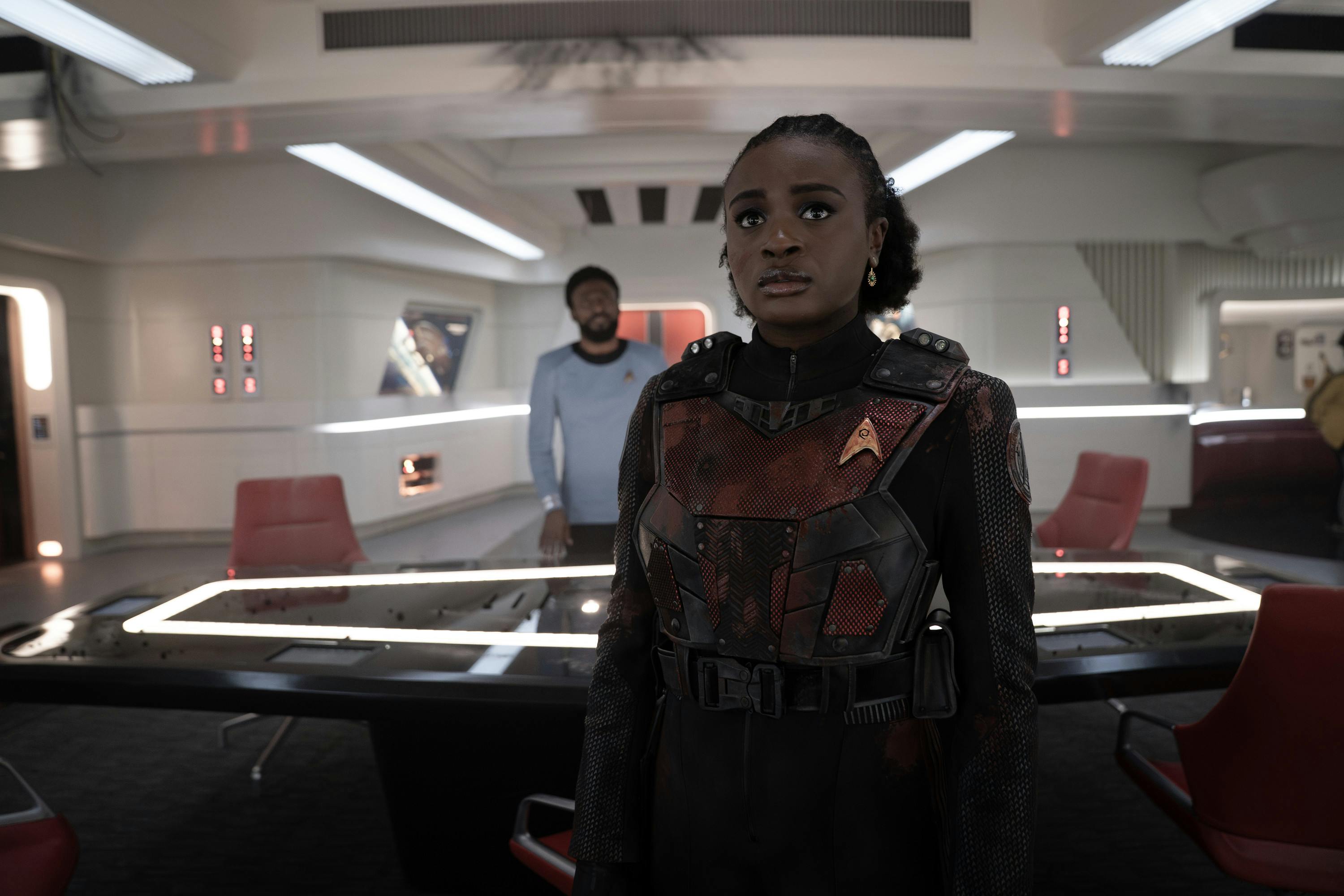 M'Benga stands behind a suited Uhura in the Ready Room in 'What is Starfleet?'