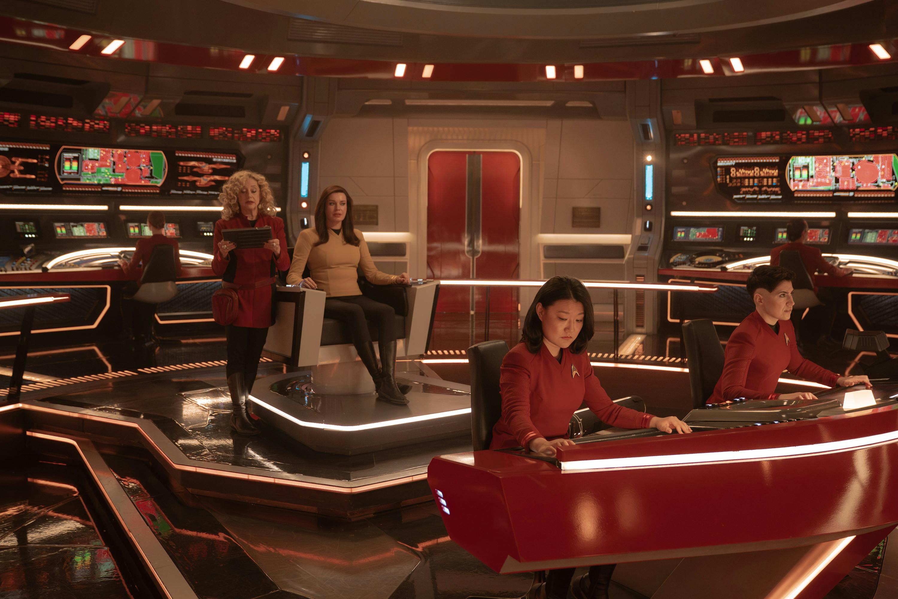 Pelia leans against Una in the command seat with Mitchell and Ortegas at their stations on the bridge in 'Four-and-a-Half Vulcans'
