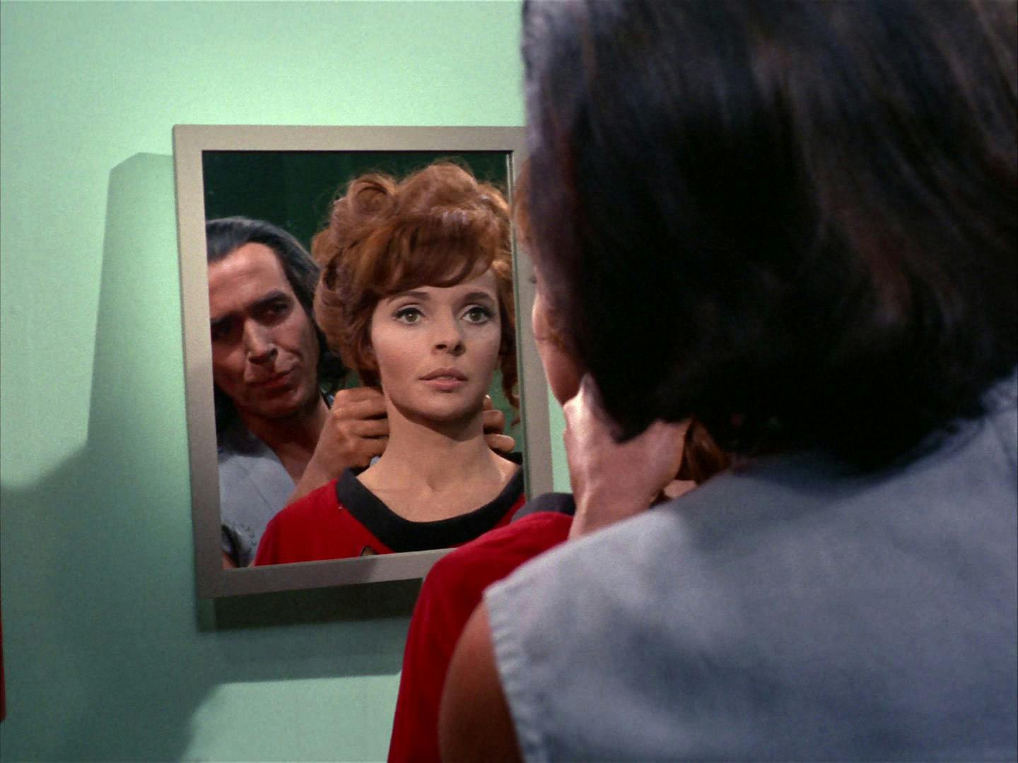 Marla McGivers looks at Khan's reflection in the mirror as he stands directly behind her in 'Space Seed'