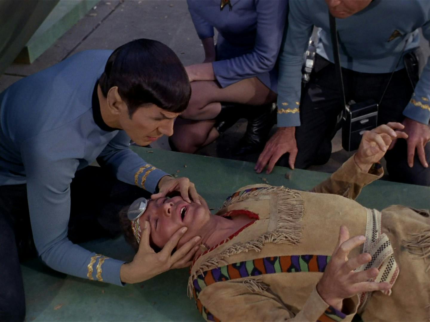 Spock mind melds with Kirk as he lays on the ground in 'The Paradise Syndrome'