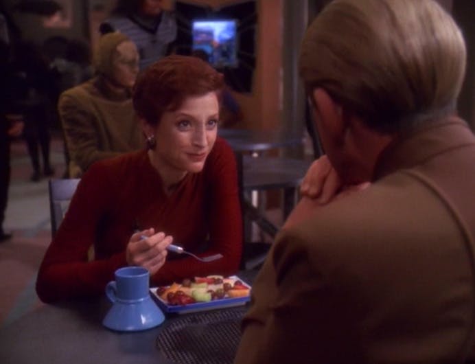 At the replimat, Kira enjoys her breakfast as she looks over at Odo in 'The Reckoning'