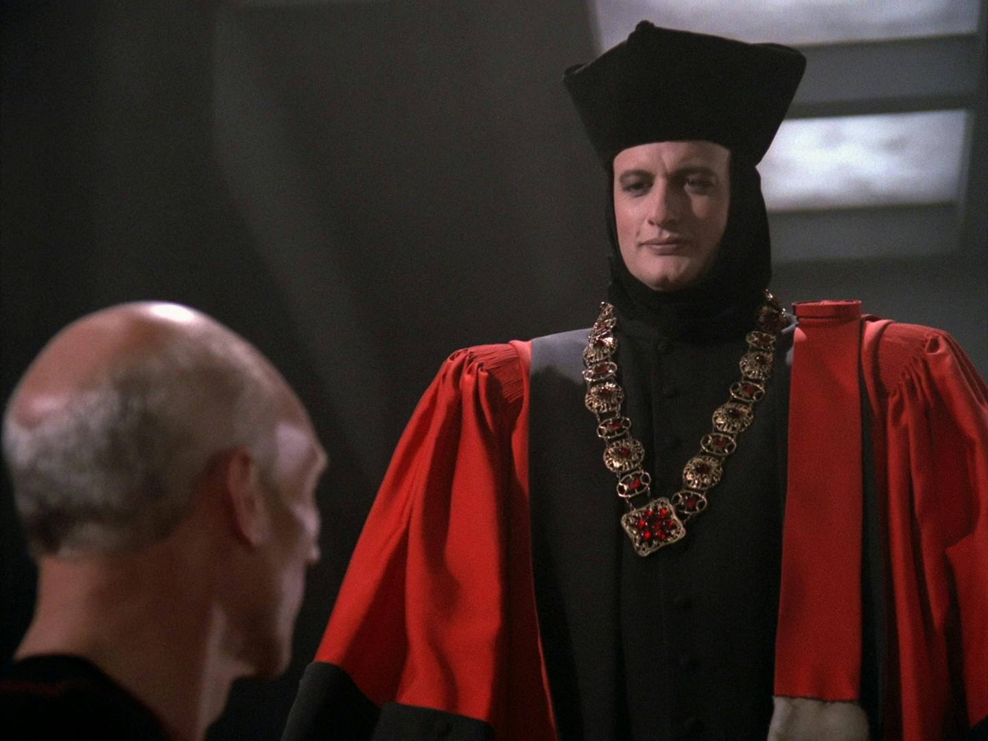 At humanity's trial, Q stands above Picard in his judge's outfit looking down upon the humans in 'Encounter at Farpoint'