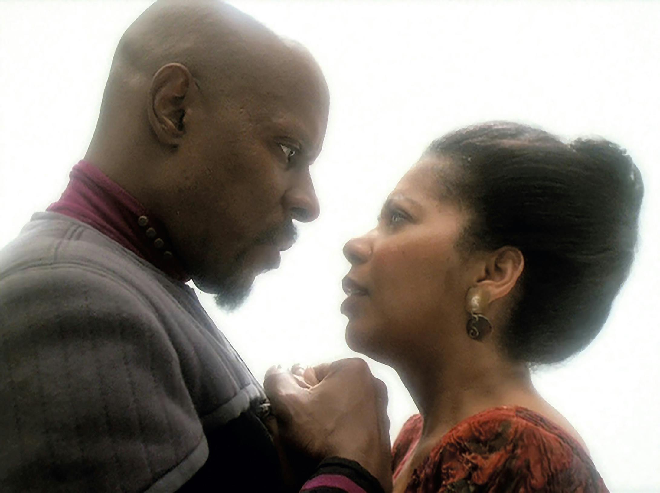 Benjamin Sisko and Kasidy Yates clasping hands as they gaze into each other's eyes in 'What You Leave Behind'