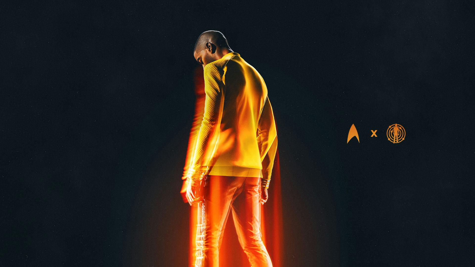 Stylistic teaser art of Kid Cudi wearing his Starfleet captain's uniform with his back turned and lit with a teleporter glow