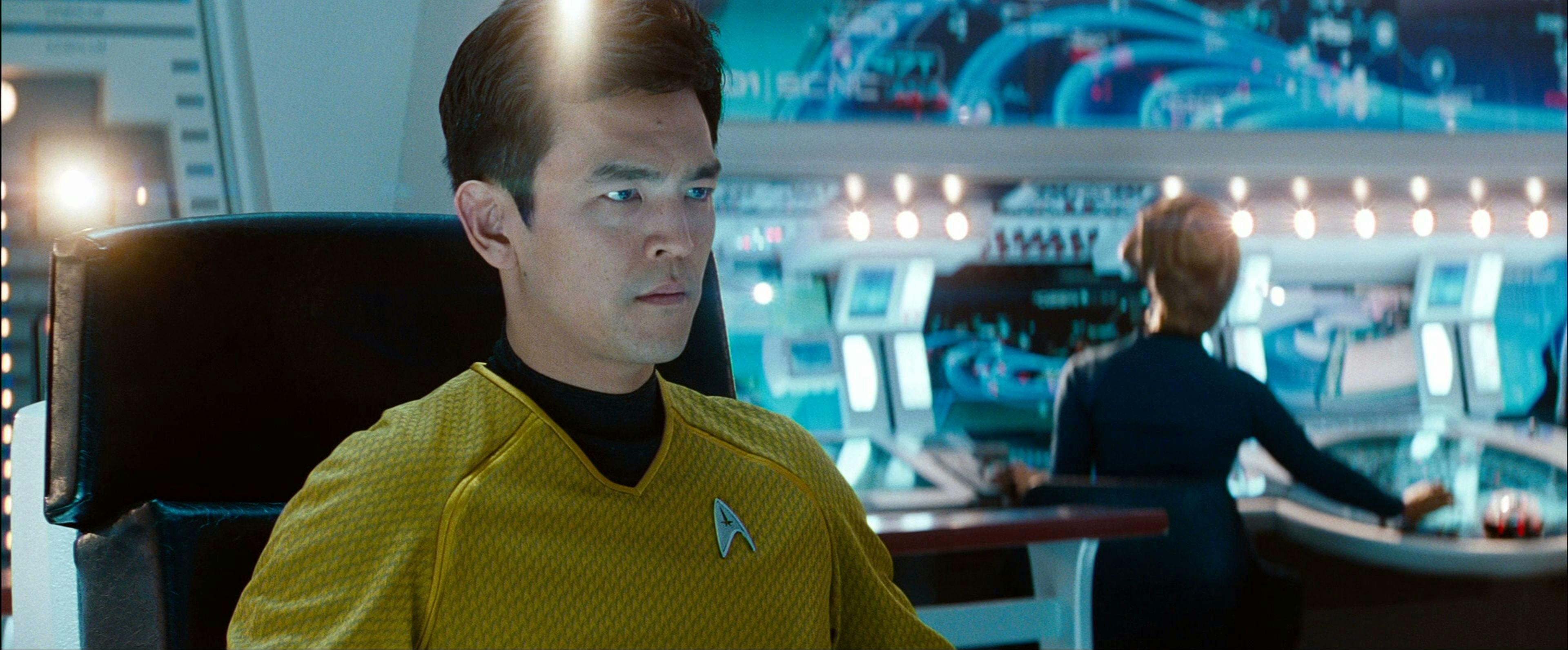 Close-up of Hikaru Sulu in the center seat of the Enterprise at the helm of his first command mission in Star Trek Into Darkness