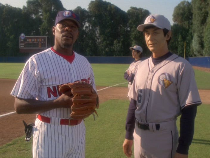 Captain Sisko and Captain Solok stand on the baseball field in their respective Niners and Logicians baseball uniforms in 'Take Me Out to the Holosuite'