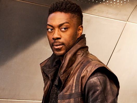 Cleveland Booker, as seen in Star Trek: Discovery, standing slightly turned, looking back over his shoulder