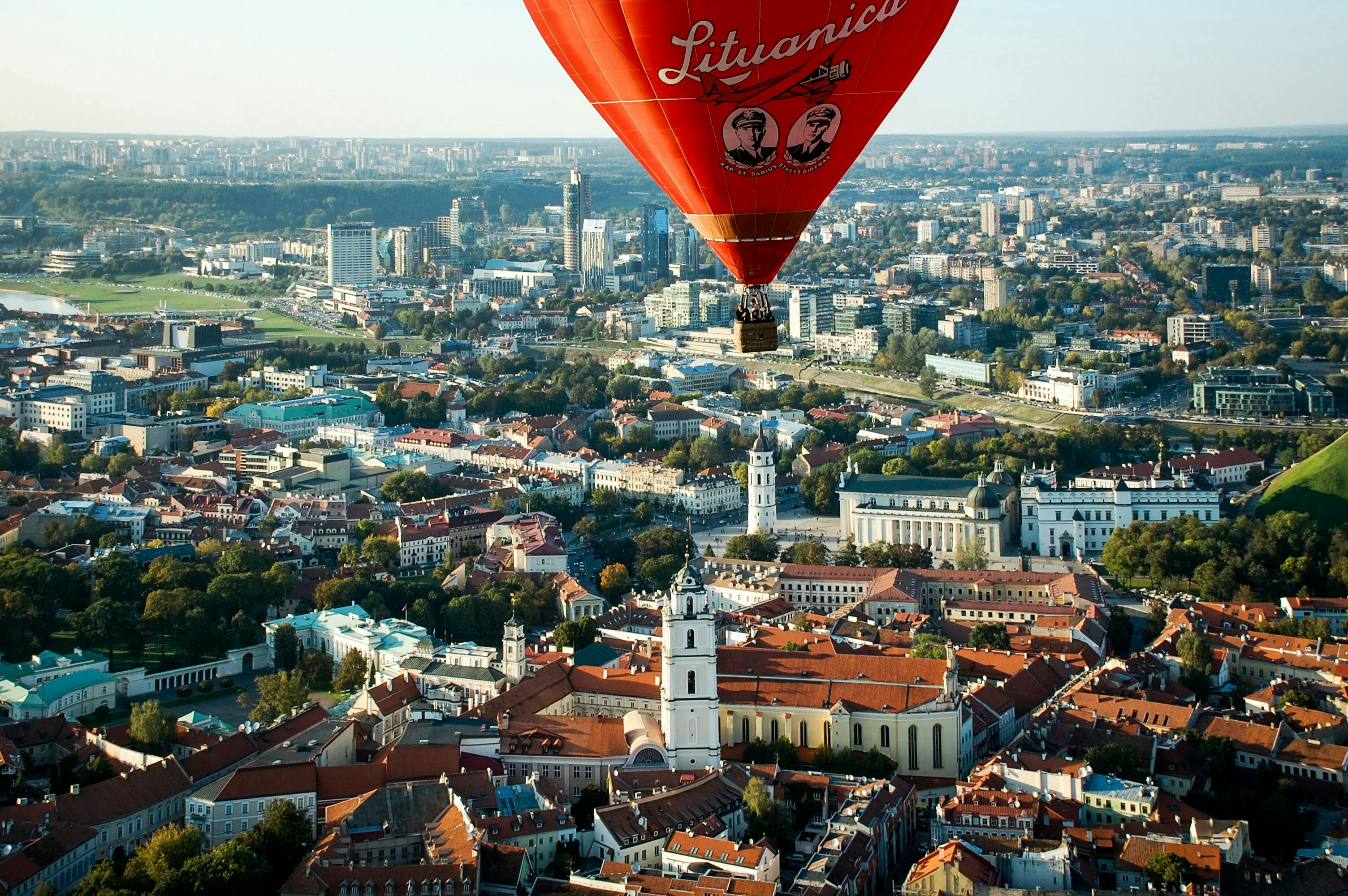 A view of the city of Vilnius in Lithuania featuring a cityscape with red-roofed buildings, historic architecture, and modern structures in the background.