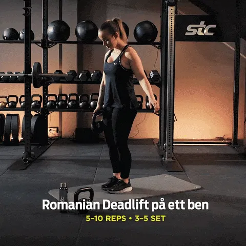 Kvinna med hantel i handen utför övningen Romanian Deadlift på ett ben, på STC-gym