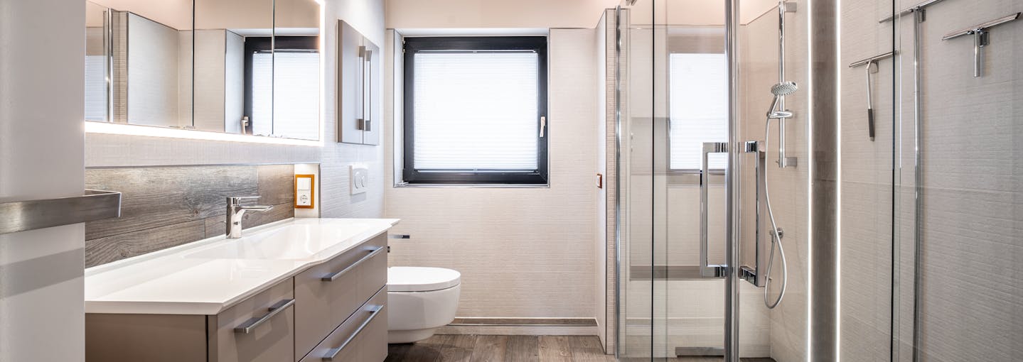 Modernes helles Badezimmer mit neuer Sanitär und großer Dusche von Steinkühler in Leverkusen.