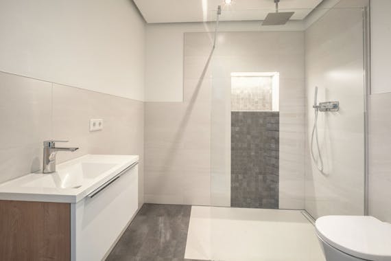 Modernes helles Badezimmer mit offener Dusche von Steinkühler in Leverkusen.