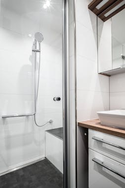 Neues Waschbecken und moderne Dusche mit Sitzmöglichkeit in einem schönen Badezimmer von Steinkühler in Leverkusen.