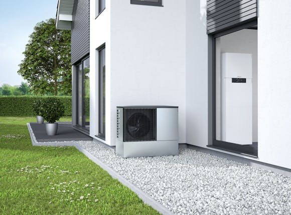 Wärmepumpe von Steinkühler in Leverkusen hinter einem modernen Haus mit großem Garten