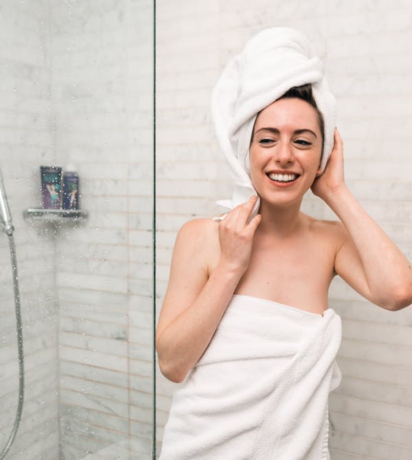 Frau ist glücklich über ihre moderne Dusche durch Badsanierung light von Steinkühler in Leverkusen.