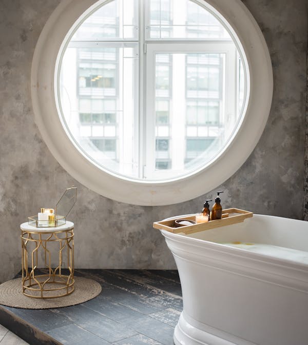 Badezimmer in einem Altbau mit großem runden Fenster mit Badewanne daneben von Steinkühler in Leverkusen.