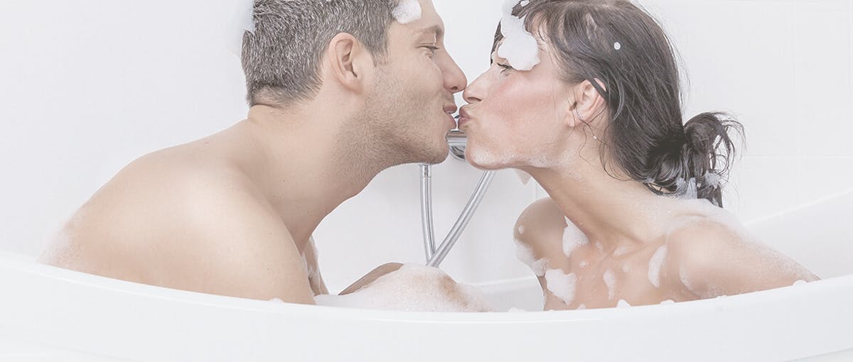 Paar küsst sich in neuer Badewanne im Badezimmer Dank der Teilbad Modernisierung von Steinkühler in Leverkusen.