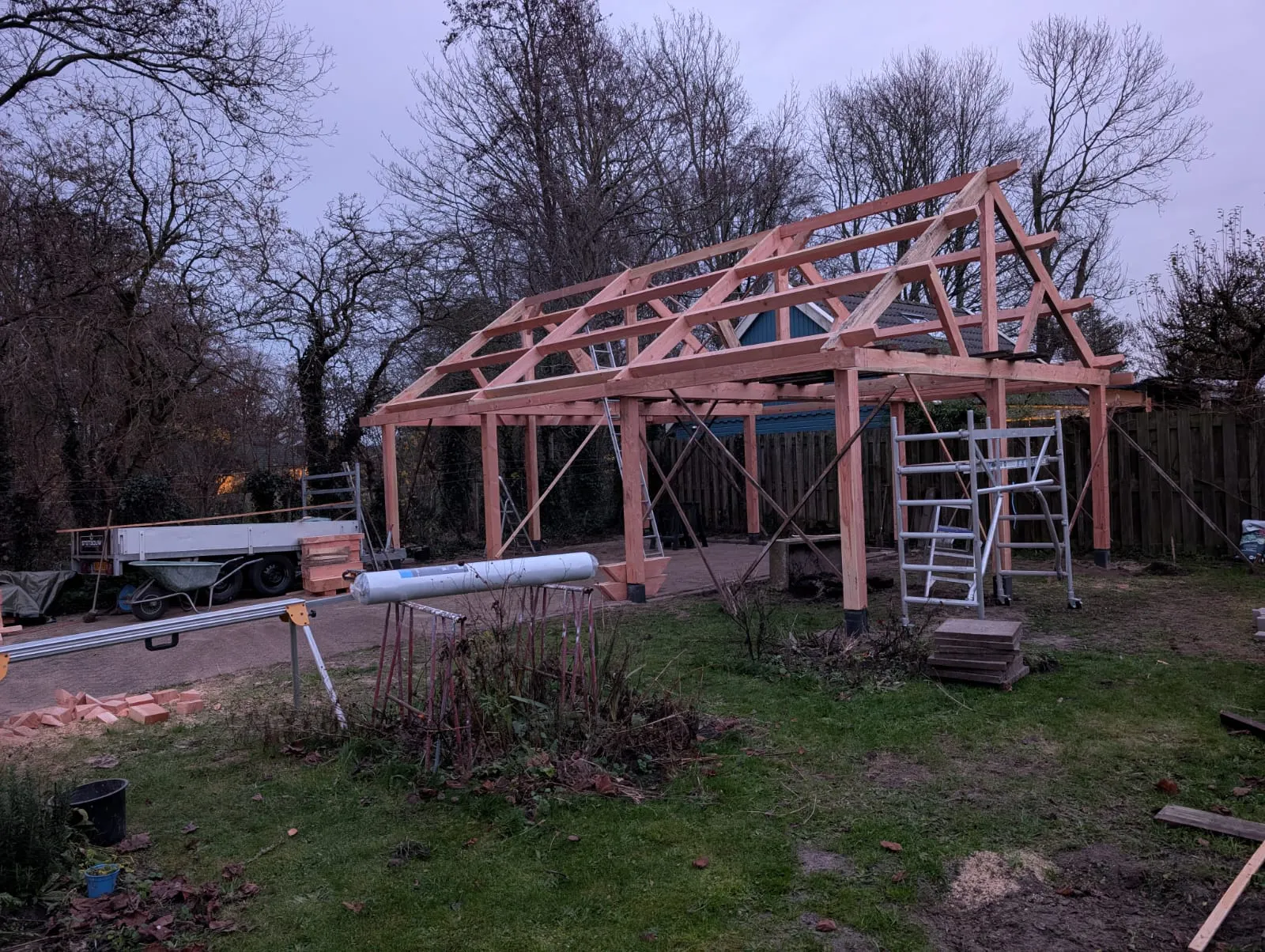 Zijaanzicht van houten draagconstructie met kapspanten in de tuin