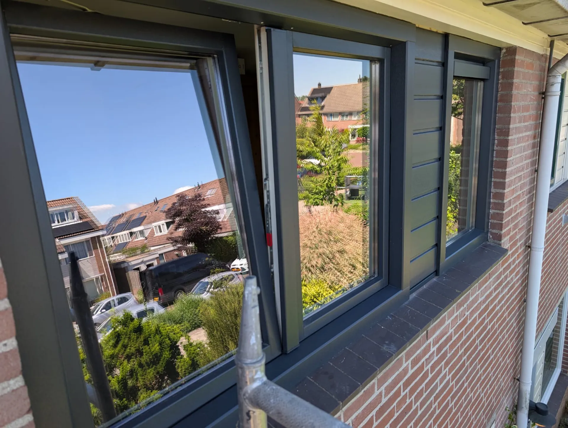 Meerdere nieuwe antracietkleurige kozijnen met isolatieglas aan de achtergevel
