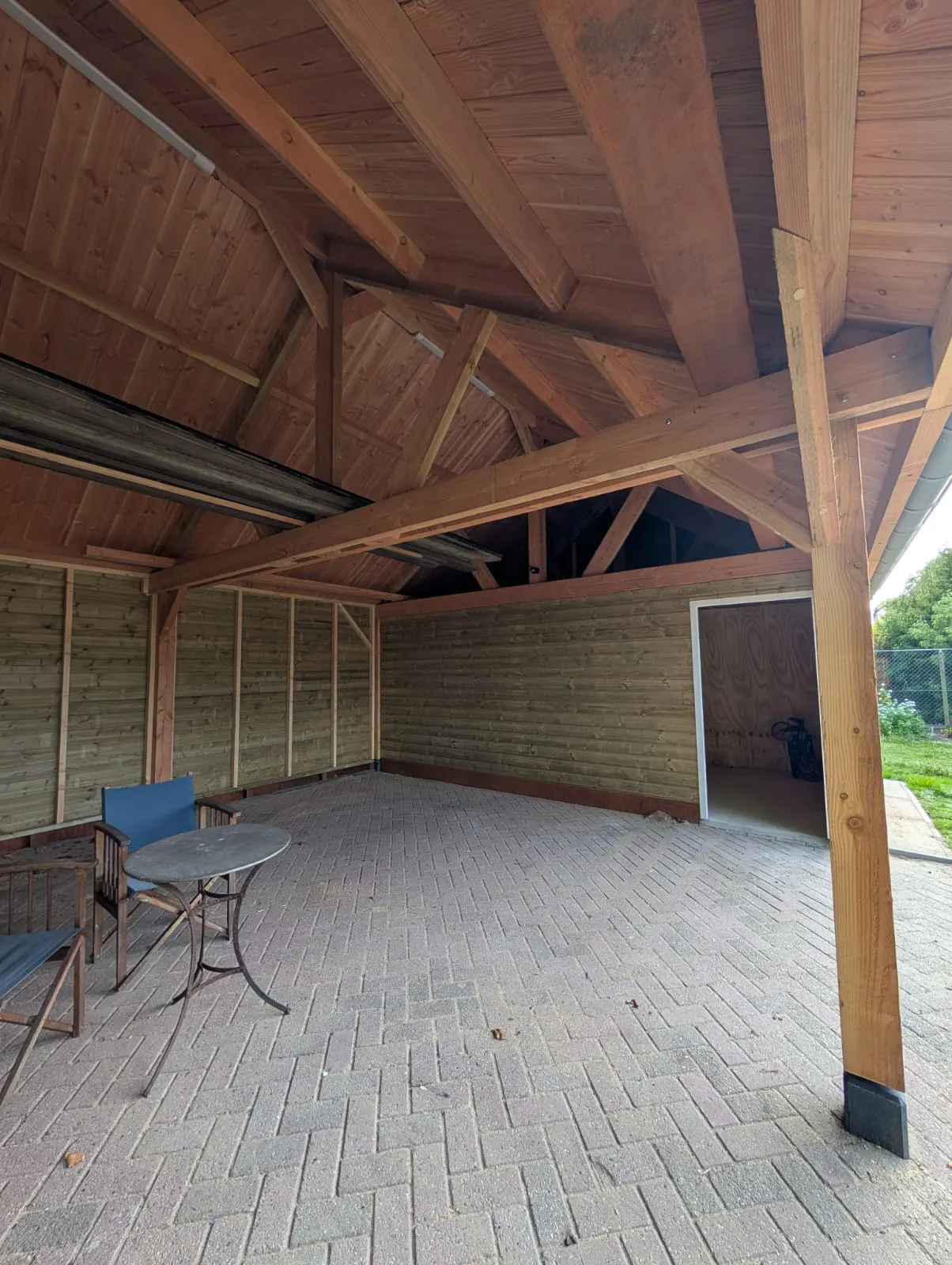 Binnenzijde van schuur en overkapping met zichtbare houten balken