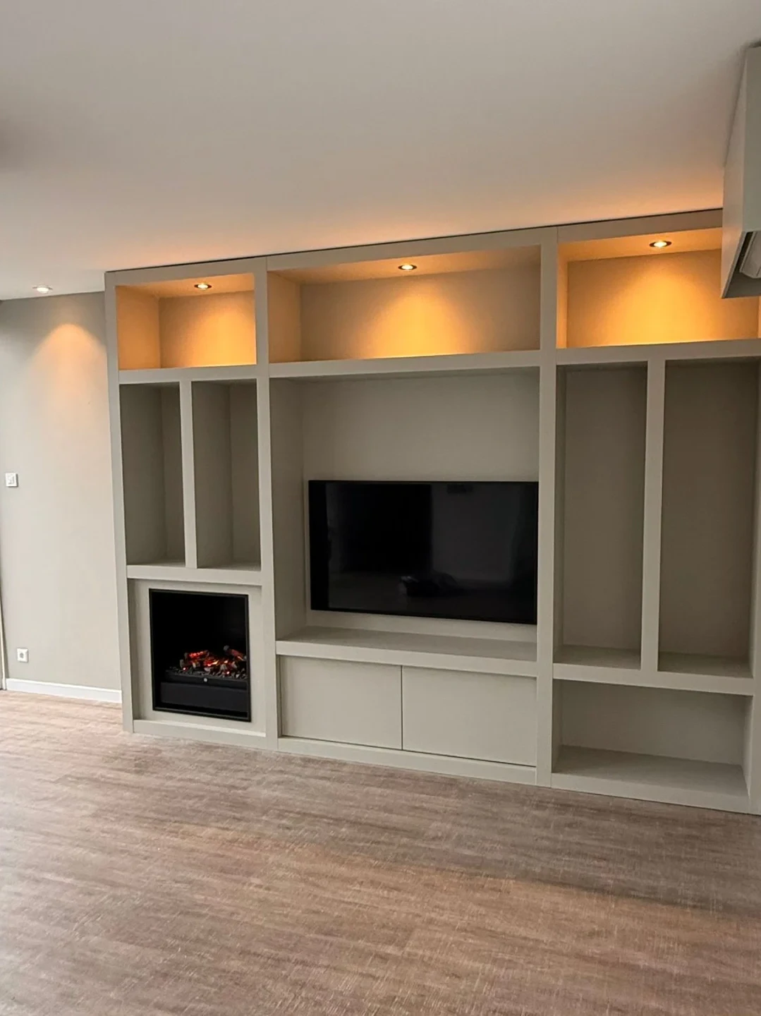Cinewall met televisie, sfeerhaard, open vakken en inbouwspots