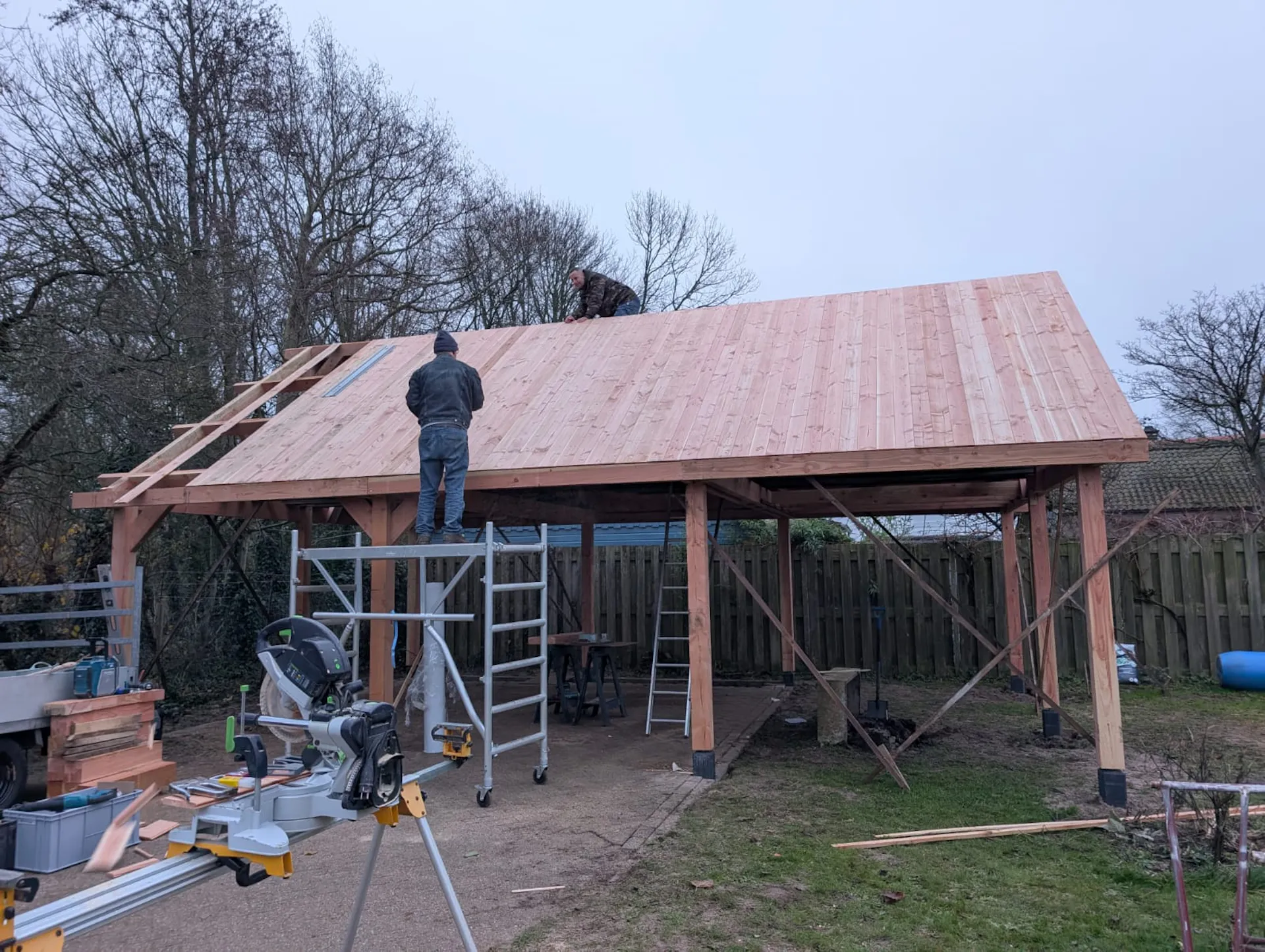 Houten dakbeschot wordt aangebracht op de nieuwe schuur in Bakkum