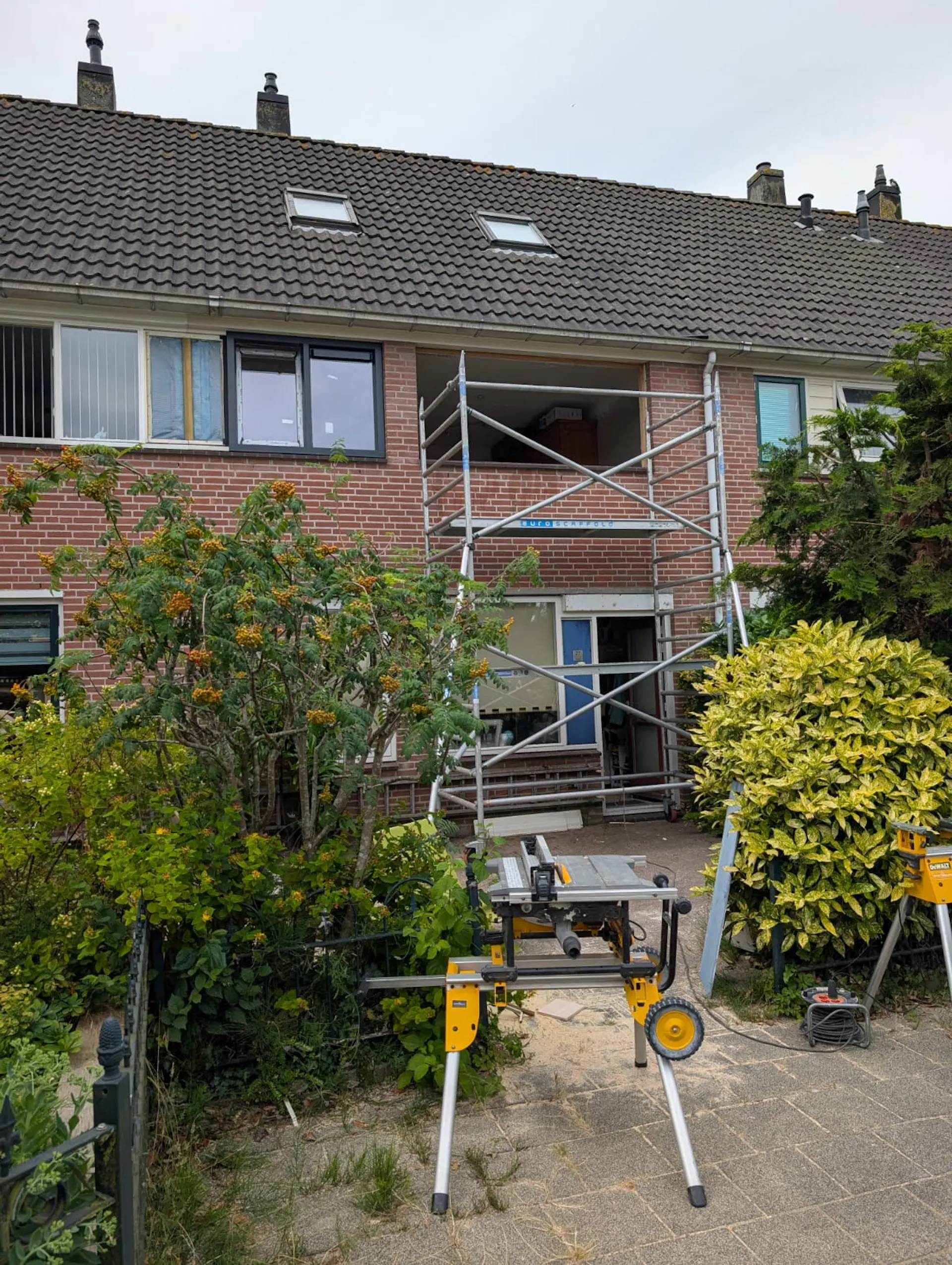 Achtergevel tijdens het vervangen van kozijnen met steiger en open raamopening