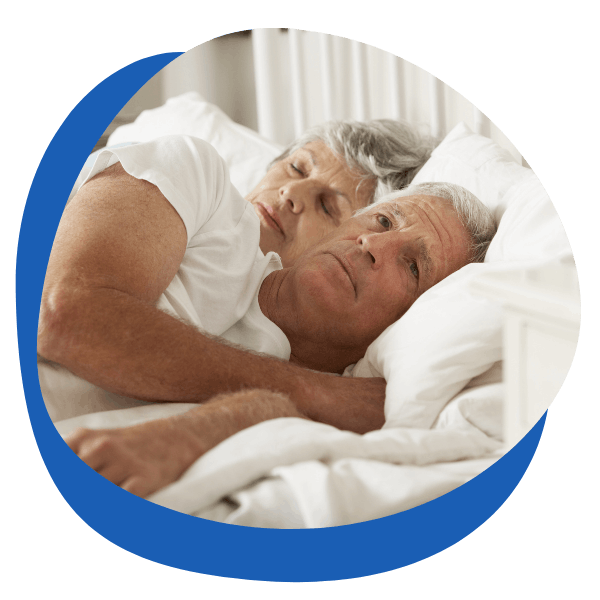 Erectile dysfunction support – An older couple lying in bed, with the man appearing concerned. Relevant for ED treatments, men's health supplements, and impotence solutions.