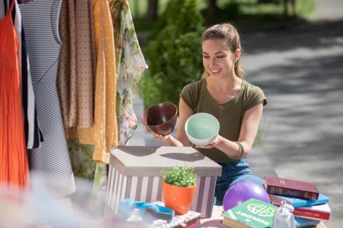 A women examining a few bowls at a garage sale