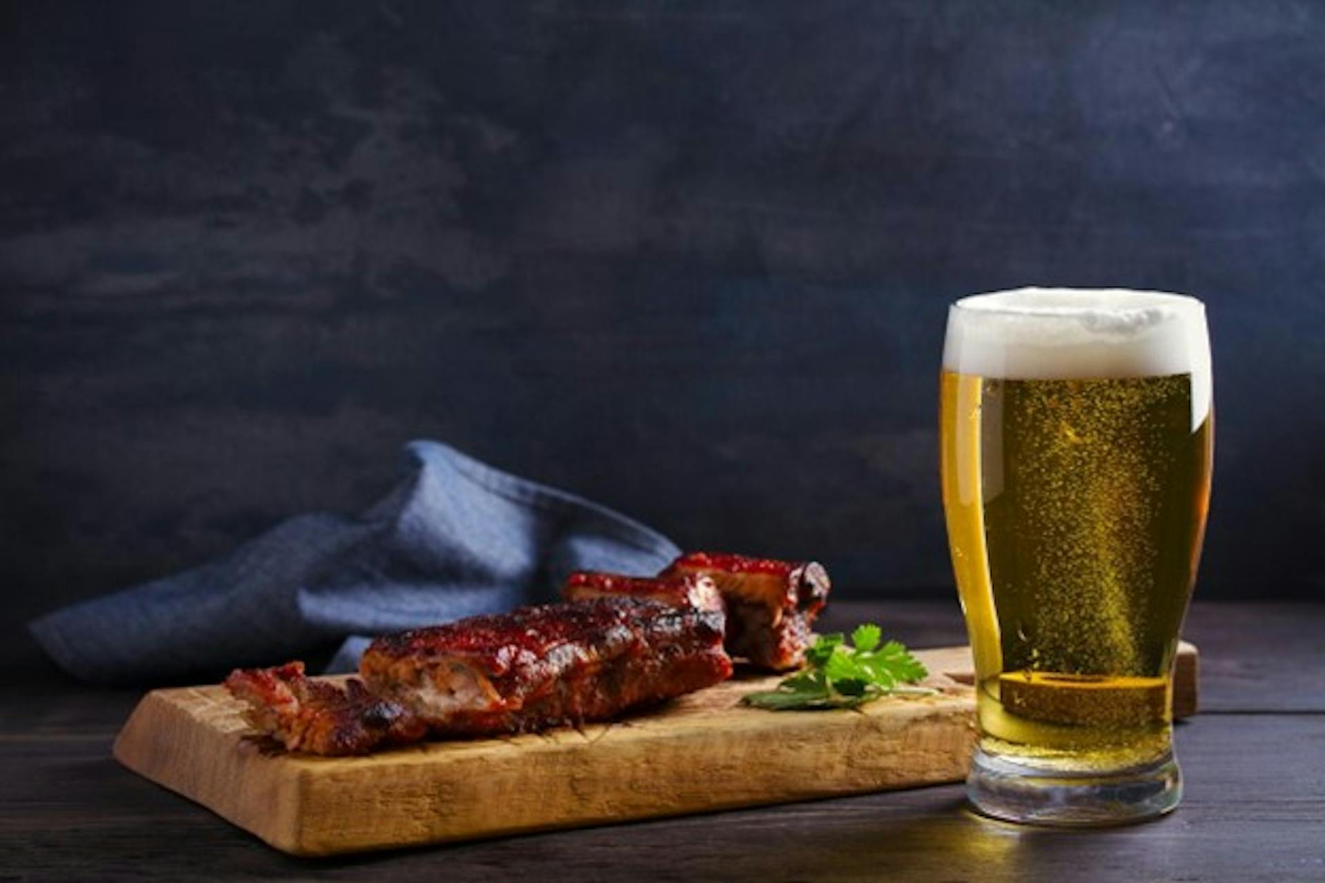 A serving of BBQ ribs accompanied by a light beer