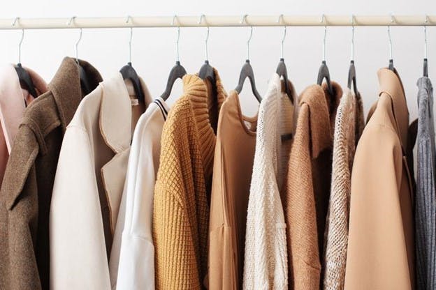 Autumn and winter tops are on hangers in a closet