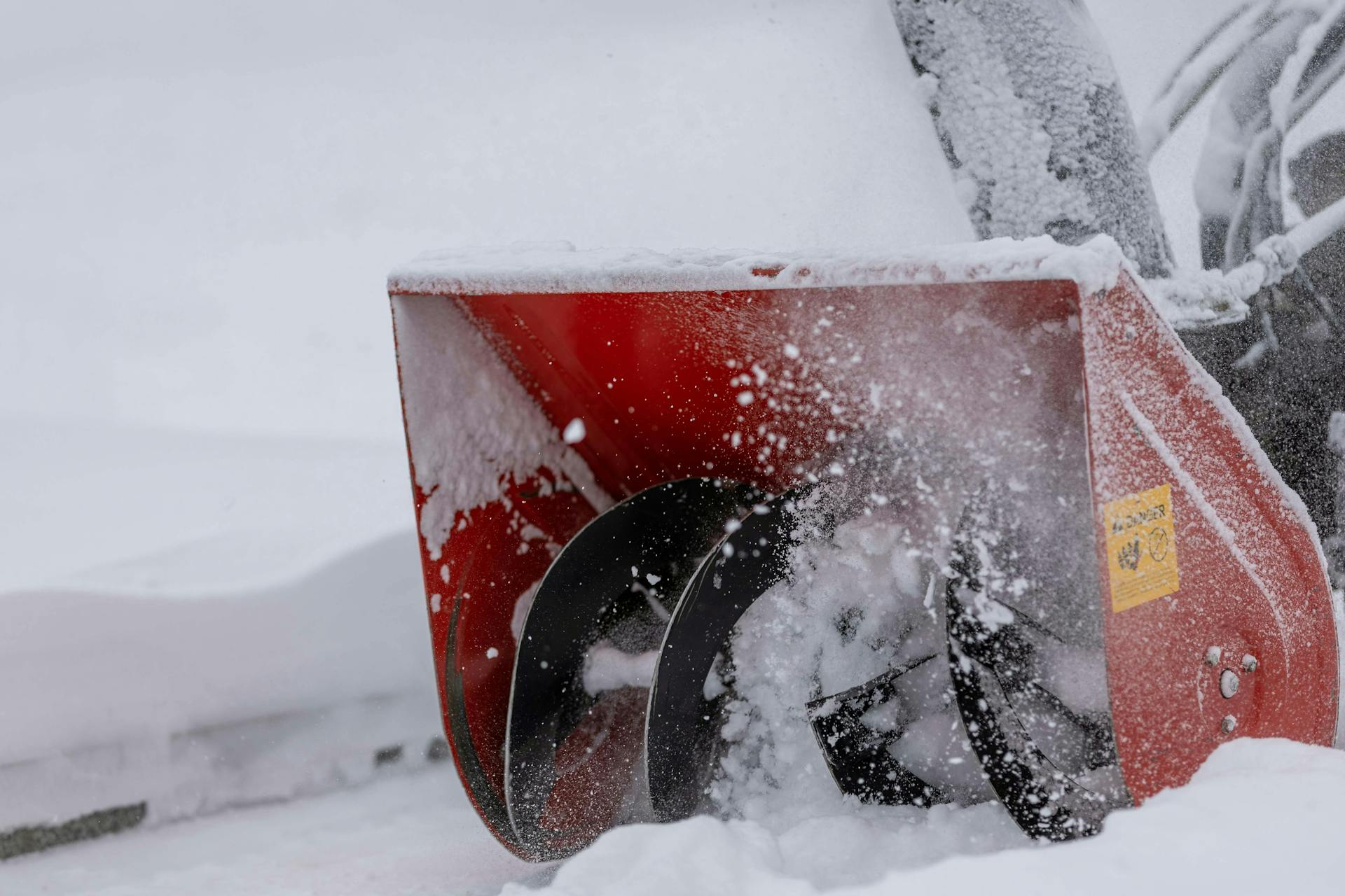 a snowblower working through a large pile of fresh snow